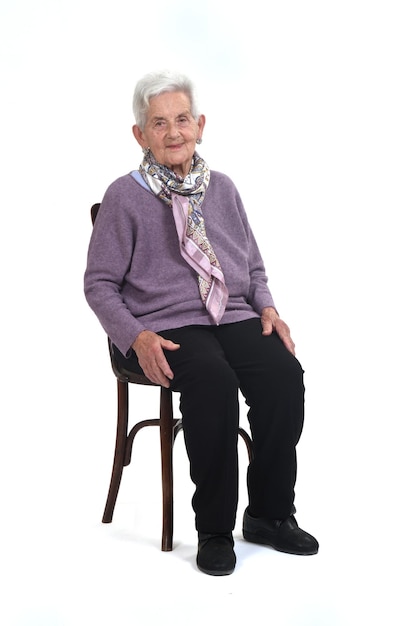 View of senior woman sitting on chair on whte background