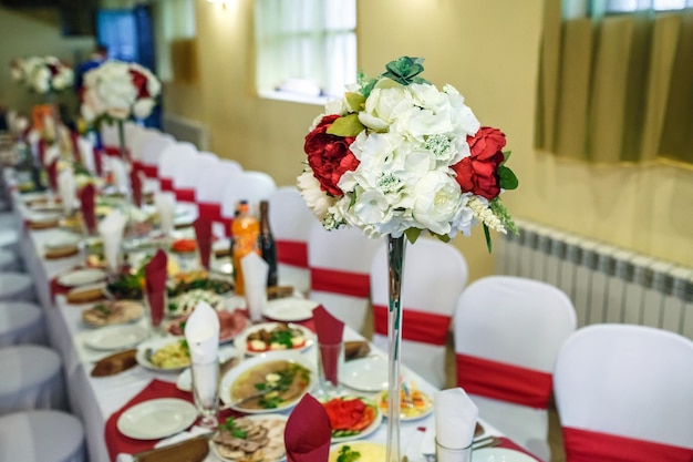 美しい花のあるエリートレストランで装飾された結婚式のディナーテーブルに提供されるビュー