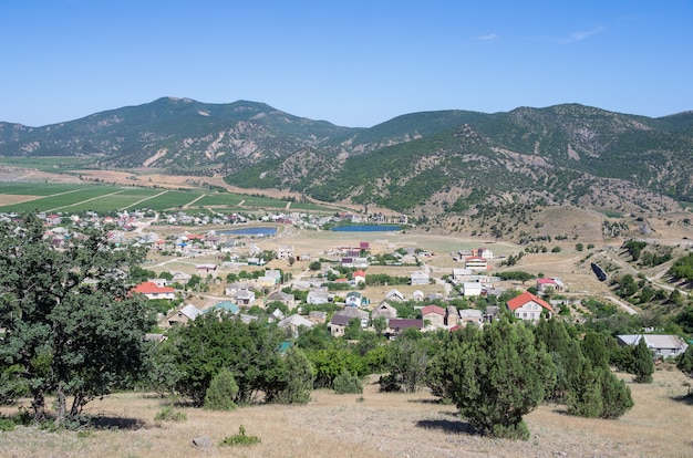 View of a settlement in a mountain valley houses outbuildings vineyards