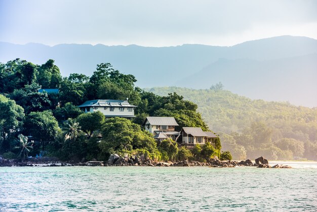 View of Seychelles coastline with houses in the forest