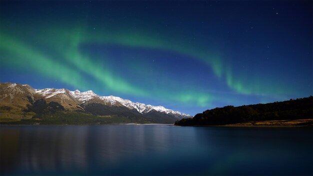 Photo a view of the sky above a lake with the aurora borealis above it.