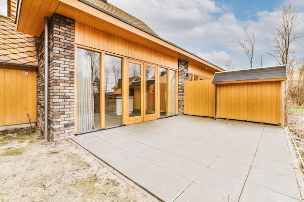 View of a small backyard of a modern cottage tiled in concrete color