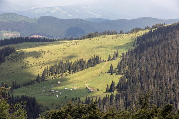 View of a small village in the valley of the mountains Polonyna in the Carpathians a wonderful summer landscape