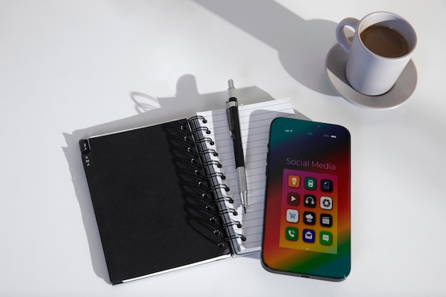 View of smartphone on desk with assortment of items