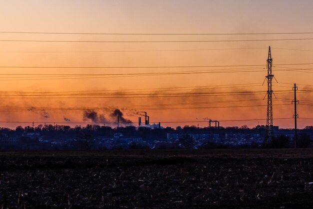 View on smoke pipes of the factory at sunset