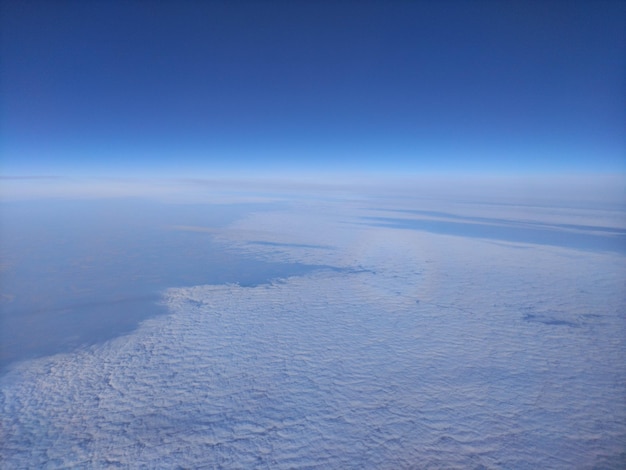 a view of the snow covered mountains from the plane window.