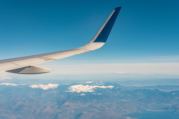 View of a snowy mountain from a window in airplane.