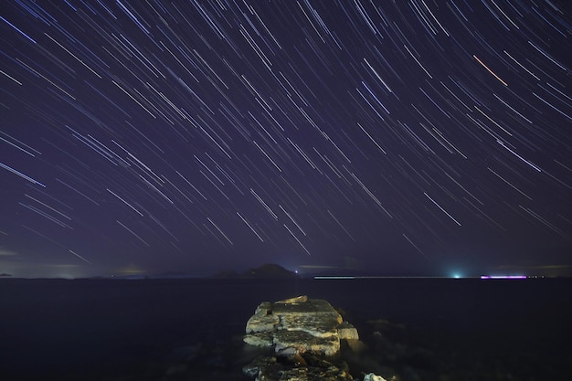 Photo a view of the stars of the milky way with a mountain top in the foreground perseid meteor shower observation