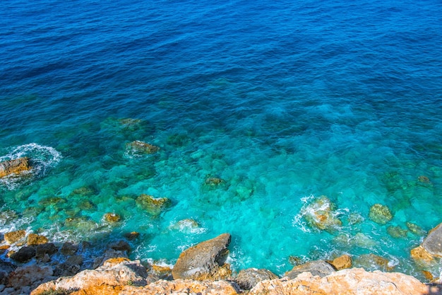 View of the stones of the coast and the heavenly turquoise water in the sea