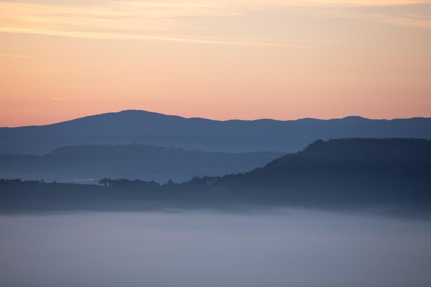 Photo view of sunrise over the mountains mist and clouds under peaks