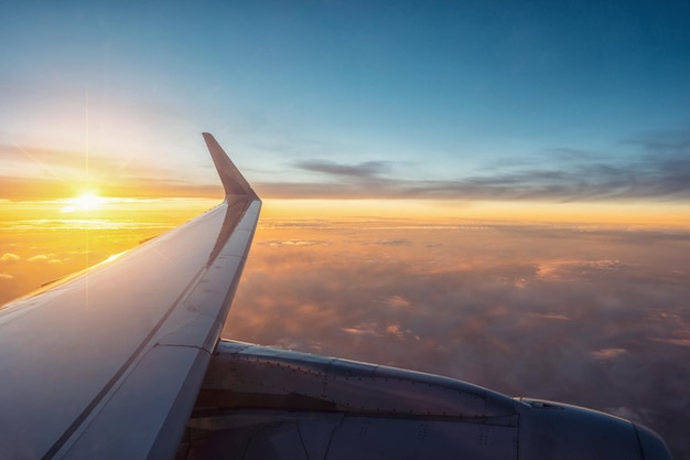 View of the sunsetclouds and airplane wing from the Inside