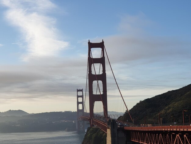 Photo view of suspension bridge against cloudy sky