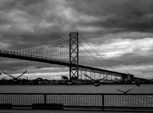 Photo view of suspension bridge against cloudy sky