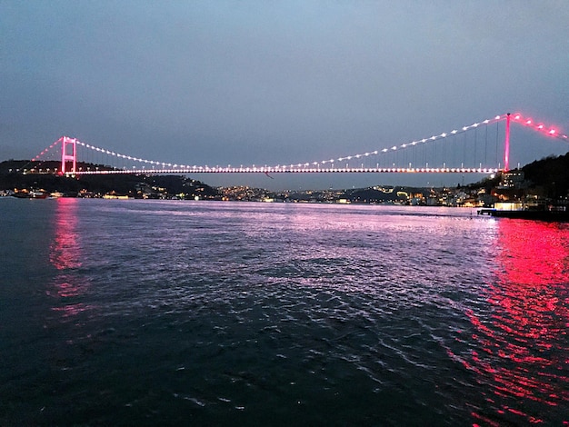 Photo view of suspension bridge over river at night