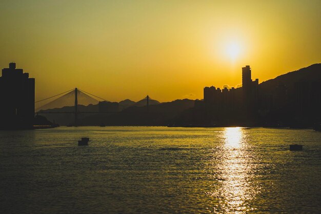 Photo view of suspension bridge over river at sunset