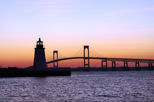 Photo view of suspension bridge over sea at sunset