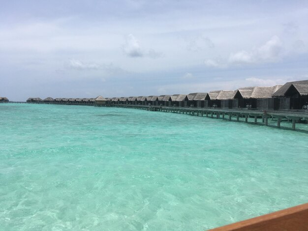 View of swimming pool in sea against cloudy sky