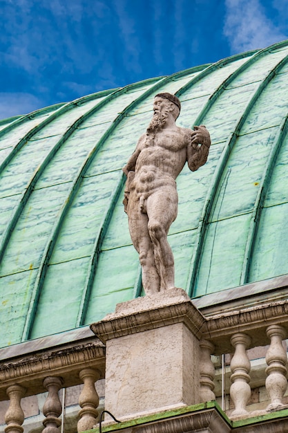 View t statue at basilica palladiana with copper roof in vicenza city in italy