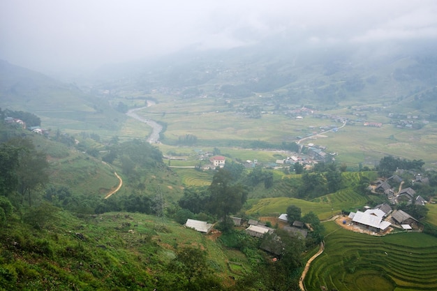 View of Tavan village on rice field terraced with river in foggy day at Sapa