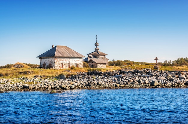 View of the temple and stone houses on the Zayatsky Islands and the White Sea coast in the rays of the autumn sun