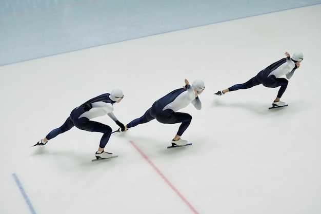 Above view of three young active athletes bending forwards during training