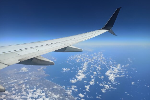 View through airplane window of commercial jet plane wing flying high in the sky Air travelling concept