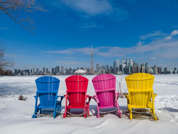 View of Toronto city skyline seen form Toronto Islands with colourful chairs