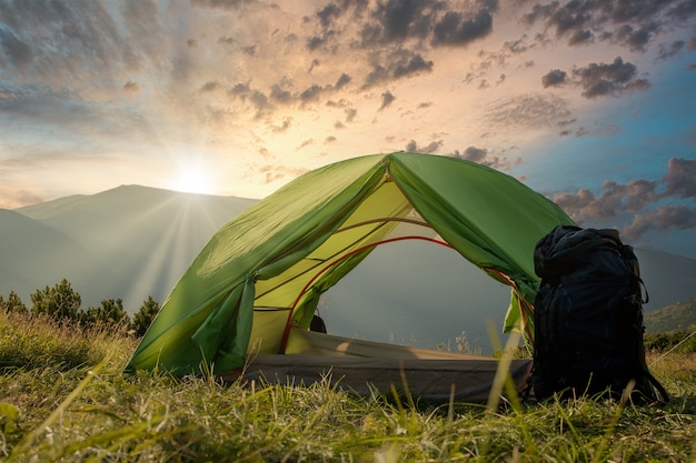 Photo view of tourist tent in mountains at sunrise or sunset.
