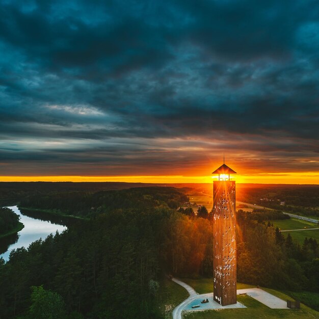 View of tower against forest during sunset