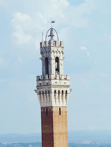 Photo view of tower by sea against sky