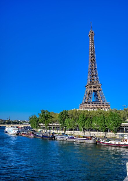 View of tower in city against clear blue sky