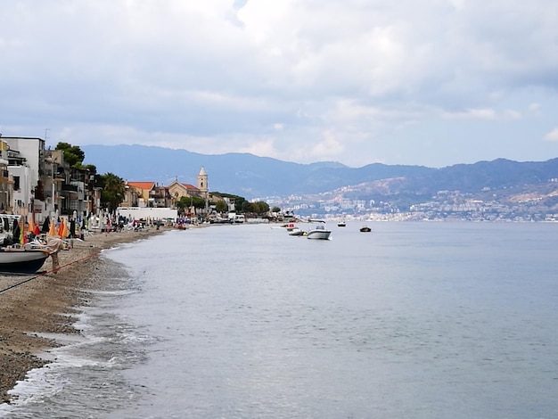 Vista della città sul mare contro un cielo nuvoloso