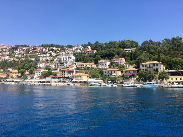 Photo view of townscape by sea against clear blue sky