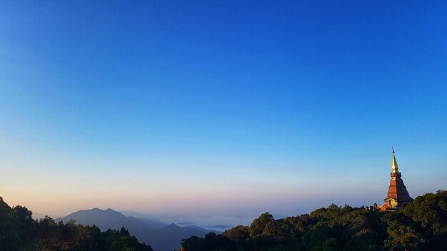 View of trees and mountain against blue sky