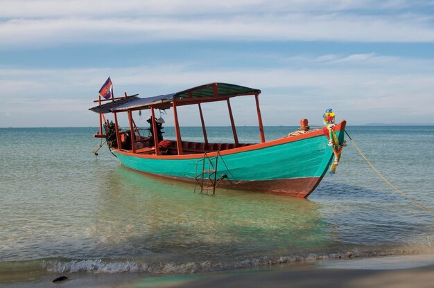 View of a typical cambodian long-tale boat anchored on the beach of otres near sihanoukville