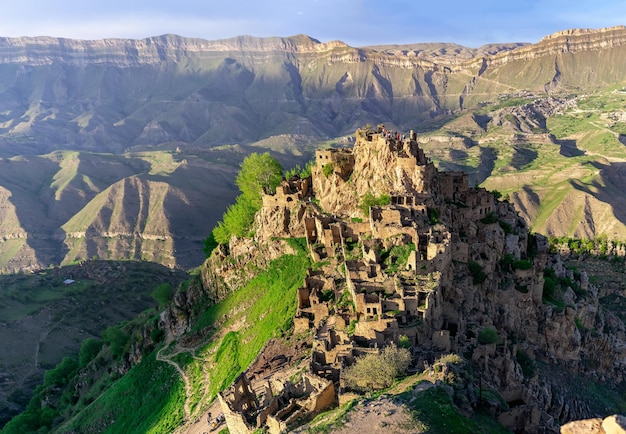 ダゲスタンの山の頂上にある無人の村Gamsutlの眺め人が住んでいるChokhの村が遠くに見えます