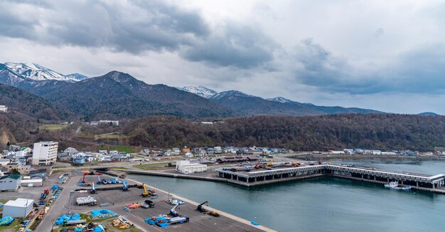 春のウトロ漁港とウトロニシ町のシレトコ山脈の景色