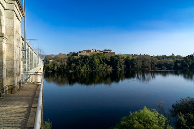 Вид крепости Валенса-де-Миньо, отражающейся в реке, и Международный железный мост