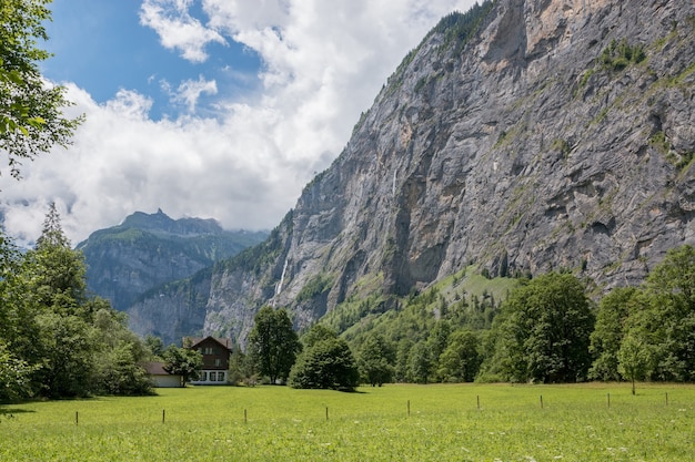 스위스, 유럽, 라우터브루넨(Lauterbrunnen) 시의 국립공원에 있는 폭포의 계곡을 보십시오. 여름 풍경, 햇살 날씨, 극적인 푸른 하늘과 화창한 날