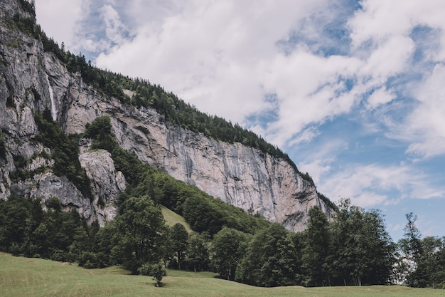 스위스, 유럽, 라우터브루넨(Lauterbrunnen) 시의 국립공원에 있는 폭포의 계곡을 보십시오. 여름 풍경, 햇살 날씨, 극적인 푸른 하늘과 화창한 날