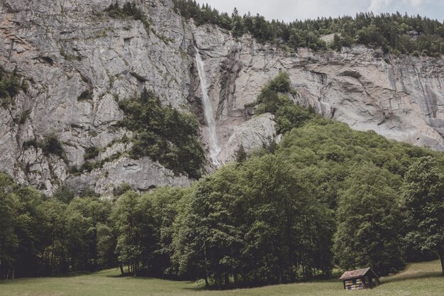 스위스, 유럽, 라우터브루넨(Lauterbrunnen) 시의 국립공원에 있는 폭포의 계곡을 보십시오. 여름 풍경, 햇살 날씨, 극적인 푸른 하늘과 화창한 날