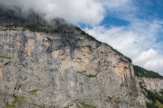 스위스, 유럽, 라우터브루넨(Lauterbrunnen) 시의 국립공원에 있는 폭포의 계곡을 보십시오. 여름 풍경, 햇살 날씨, 극적인 푸른 하늘과 화창한 날