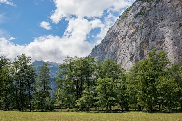 스위스, 유럽, 라우터브루넨(Lauterbrunnen) 시의 국립공원에 있는 폭포의 계곡을 보십시오. 여름 풍경, 햇살 날씨, 극적인 푸른 하늘과 화창한 날