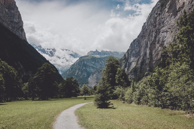 스위스, 유럽, 라우터브루넨(Lauterbrunnen) 시의 국립공원에 있는 폭포의 계곡을 보십시오. 여름 풍경, 햇살 날씨, 극적인 푸른 하늘과 화창한 날