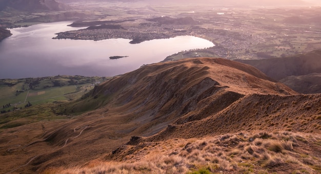 View on valley with lake during sunrise shot made on roys peak summit in wanaka new zealand