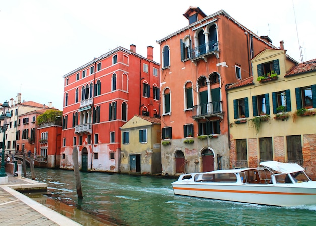 베네치아 가옥과 운하를 따라 떠 있는 보트의 전망.