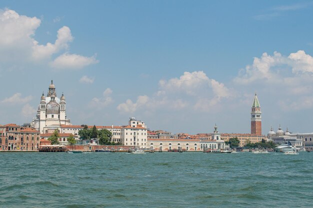 View of the Venice Canal embankment on a warm summer day, with floating boats and old houses, Venice