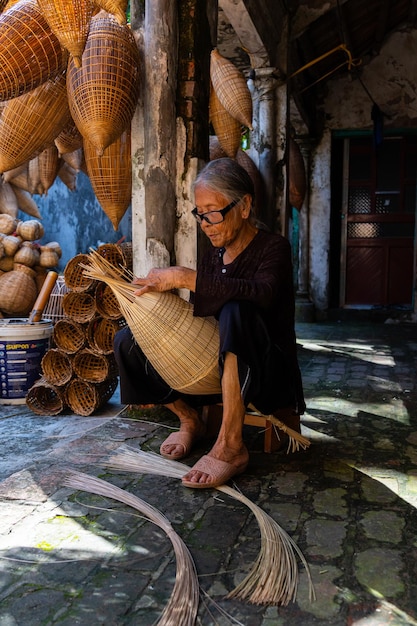 View of vietnamese craftsman making the traditional bamboo fish trap or weave at the old traditional house in thu sy trade village hung yen vietnam