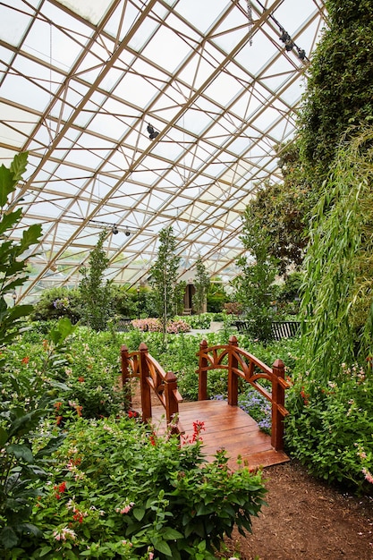 View of walking path and small bridge in Indiana botanical gardens with glass roof