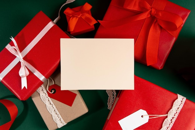 View Of A White Sheet Against A Background Of Christmas presents. Mockup Postcards.